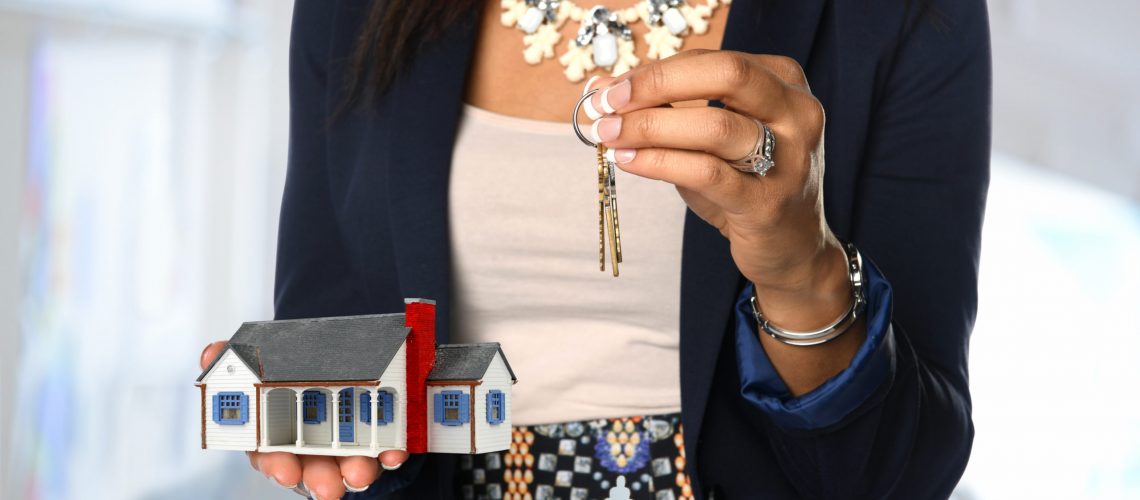Female real estate agent holding house and keys